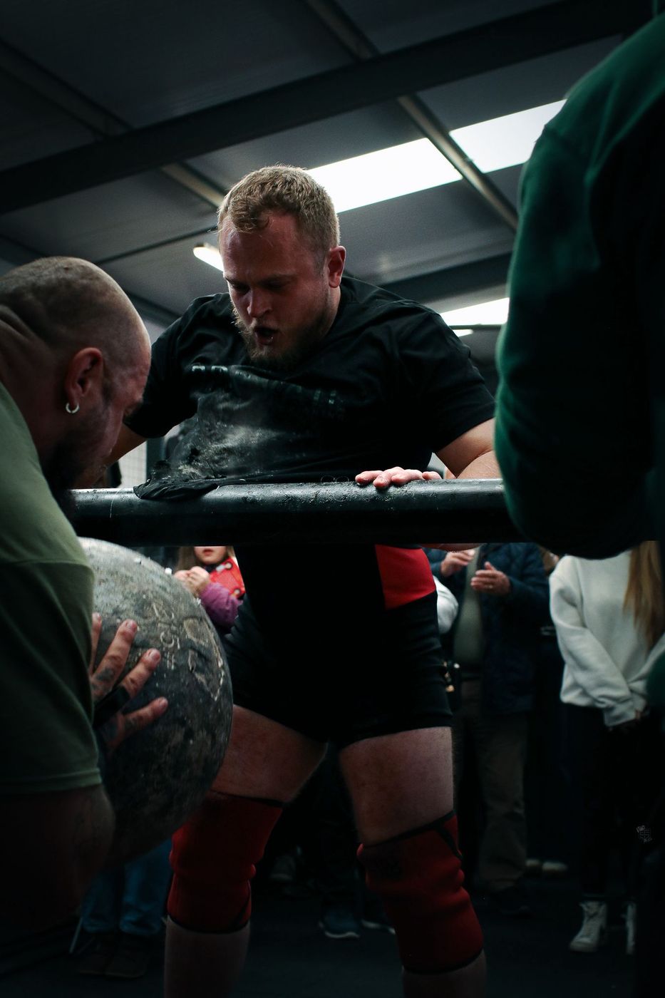 Ben Stacey feeding an atlas stone back to Team Stacey athlete Hal